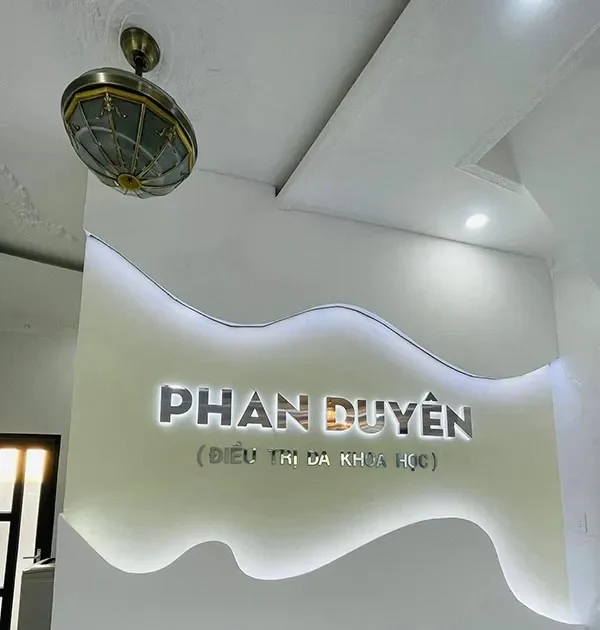 Logo inox hắt sáng chân trên vách lễ tân