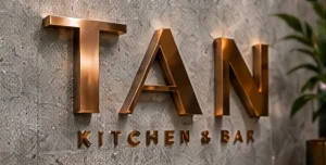 Mẫu chữ nổi màu đồng trên tường xám